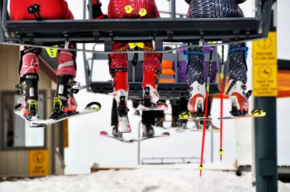 Three skiers riding a chair lift