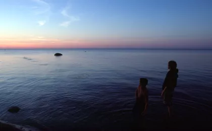 Kids wading in Lake of the Woods at dusk, Zippel Bay State Park