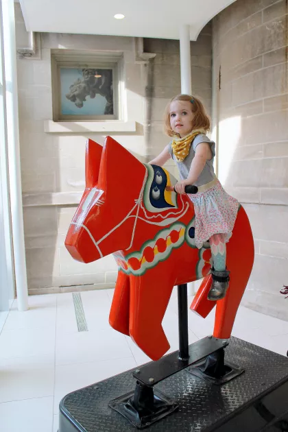 Little girl on Dala horse at the American Swedish Institute