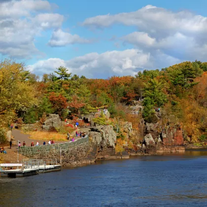 People in a park with fall trees overlooking the St. Croix River