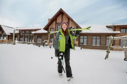 Teenager with skis outside lodge at Detroit Mountain ski area