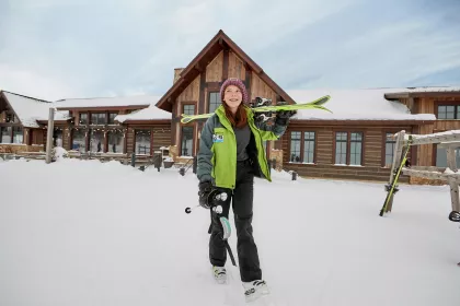 Teenager with skis outside lodge at Detroit Mountain ski area