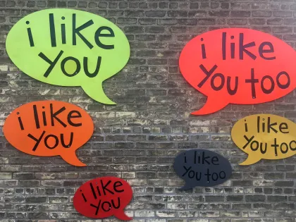 Brick exterior of store with colorful "i like you" speech bubbles