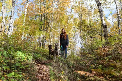 Woman hiking with dogs in Lester Park, Duluth.