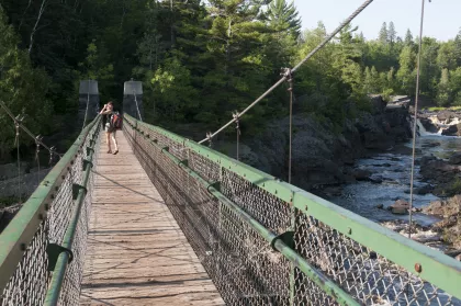 Hiker on the suspension bridge at Jay Cooke State Park