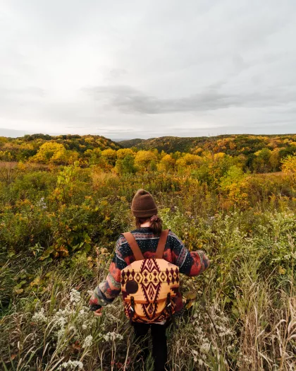 Woman hiking through a field of prairie grasses at Great River Bluffs State Park