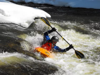 A kayaker takes advantage of the winter white caps as he navigates down the river
