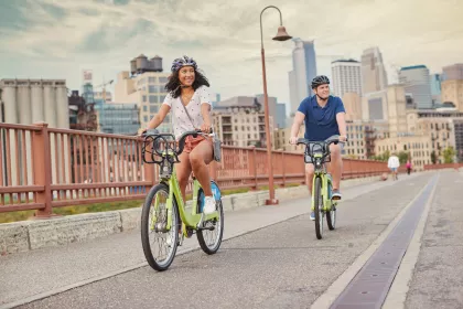 Man and woman biking on the Stone Arch Bridge in Minneapolis