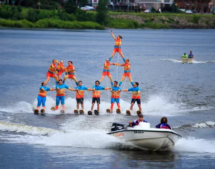 Twelve water skiers in the process of making a human pyramid