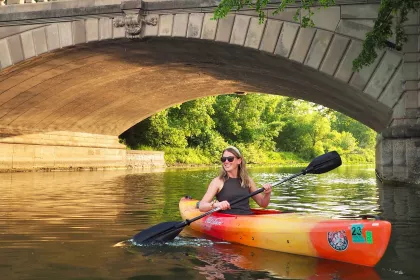 Sara kayaking near a small bridge