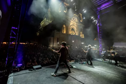 A band plays in front a a large audience in front of the Basilica of St. Mary in Minneapolis