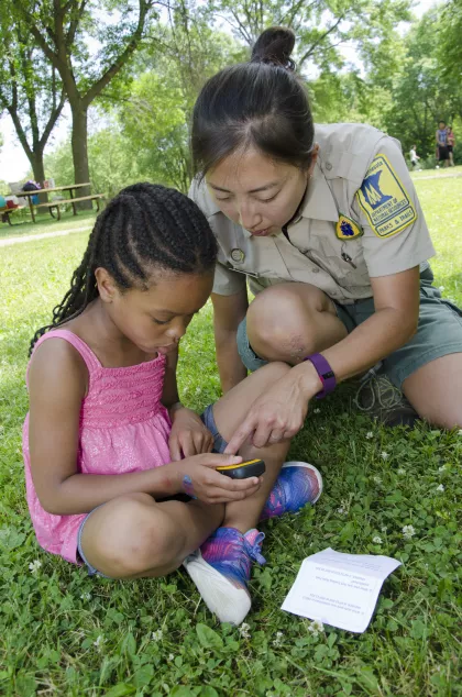 park naturalist showing a young girl how to use a GPS unit