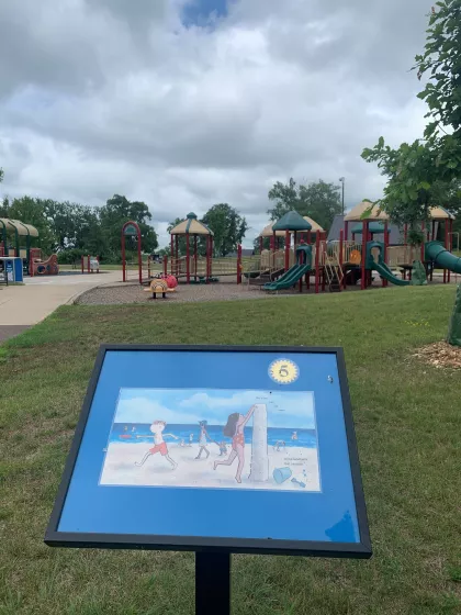 Page of a story on a sign with playground in background