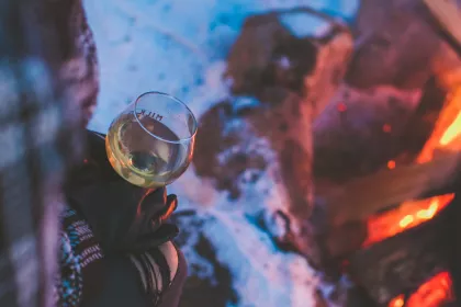 A customer drinks cider by a bonfire at Milk &amp; Honey