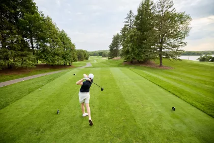 A women swings a golf club at the Baker National Golf Course