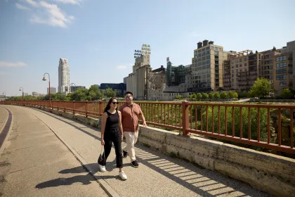 Two friends walk across the Stone Arch Bridge in Minneapolis