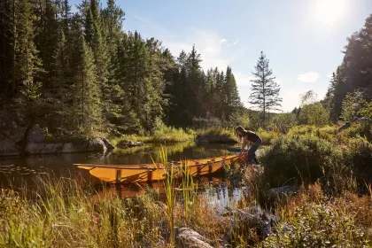 A woman portages a canoe in the Boundary Waters