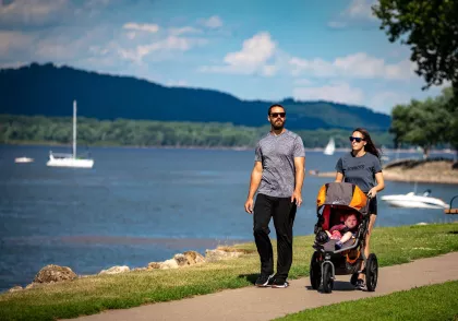 A couple walks along Lake City's Riverwalk with a stroller