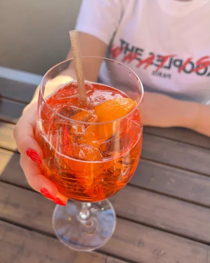 A woman clutches a cocktail on Red Rabbit's patio