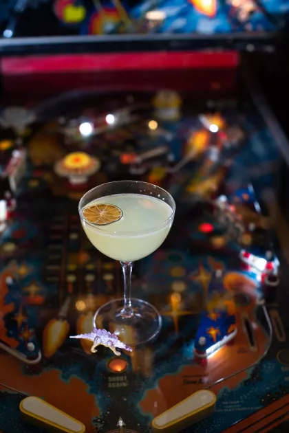 A cocktail atop a pinball machine at Meteor