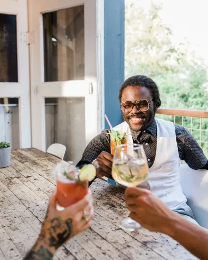 A group of friends toast their cocktails at Norseman Distillery