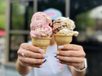 An employee holds up two ice cream cones at Adele's Frozen Custard