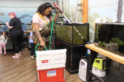 Educator Vanessa Martinez works with trout at the Headwaters Science Center