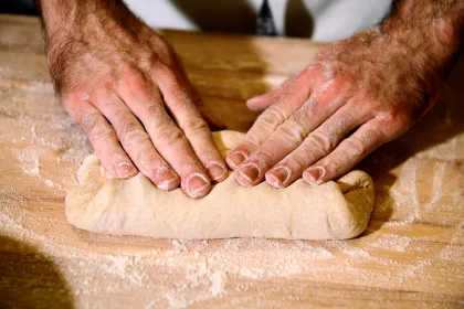 A baker kneads dough using Baker's Field Flour