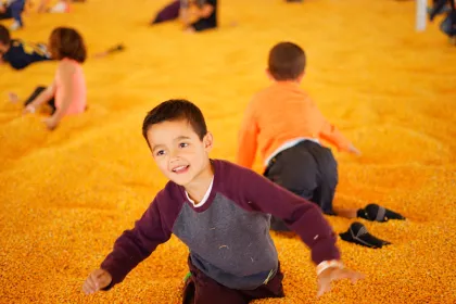 Kids jump in the corn pit at Twin Cities Harvest Festival and Maze