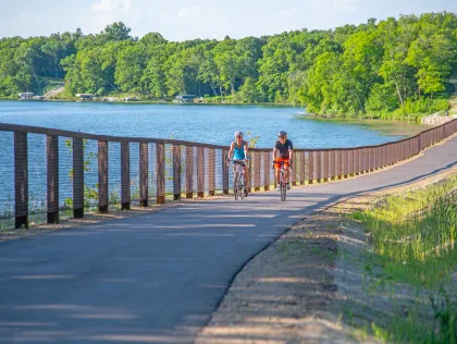 A couple bikers pass Acorn Lake on the Heartland State Trail