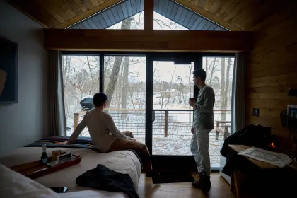 A couple friends look out at snow from their Cuyuna Cove cabin