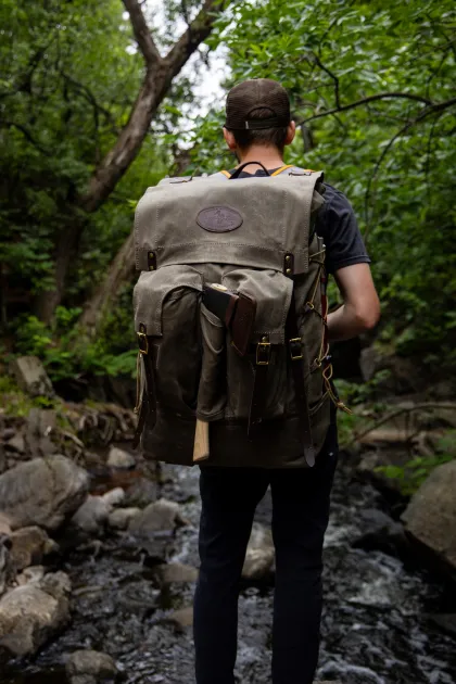 A hiker wears a Frost River backpack