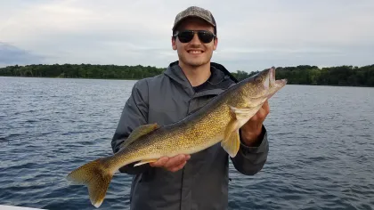A fisherman holds a walleye in Maple Lake