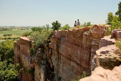 A couple hikers stand atop the quartzite at Blue Mounds State Park