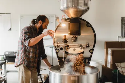 An employee roasts beans at Fika Coffee