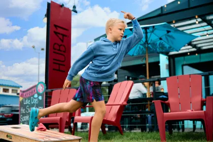 A kid plays cornhole at Hub 41 in Detroit Lakes