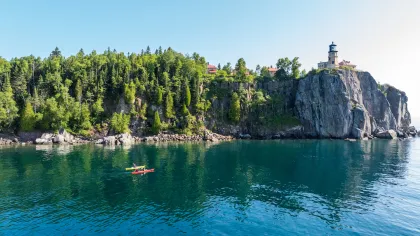 Two people paddle on Lake Superior near Split Rock Lighthouse
