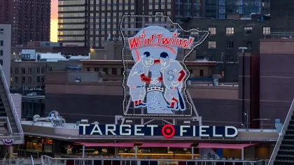 Twins icons Minny and Paul shake hands above Target Field
