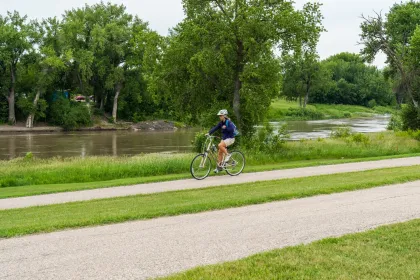 A biker along the paved Greenway trail in East Grand Forks