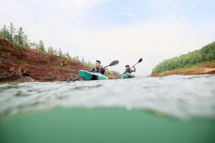 A couple of friends paddle the mine pit at Redhead Mountain Bike Park