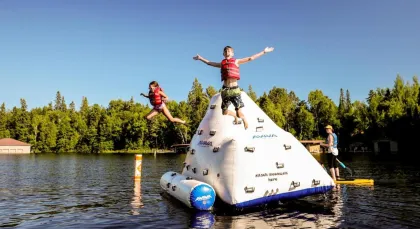 A couple kids jump into the lake at Ludlow's Island Resort