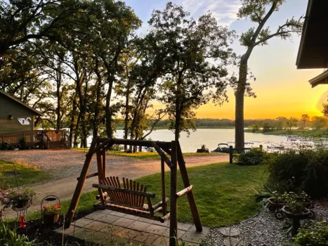 Bench overlooking river during sunset