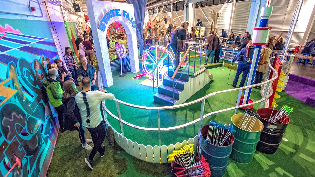 Gente jugando al mini golf en Can Can Wonderland en St. Paul