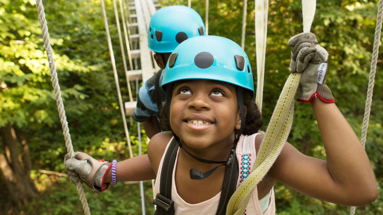 Girl on zip line suspension bridge