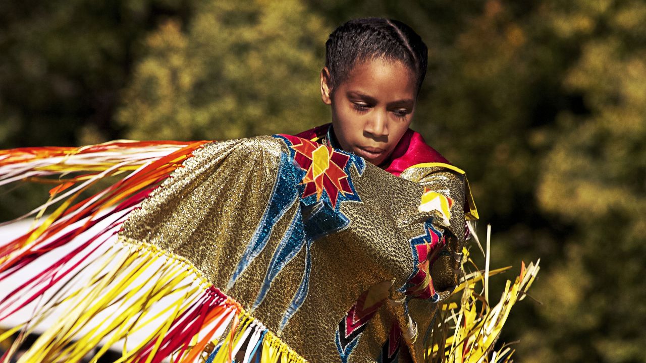 Joven bailarina en ropa tradicional de pow wow