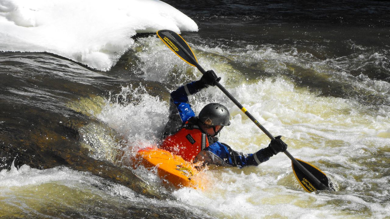 A kayaker takes advantage of the winter white caps as he navigates down the river