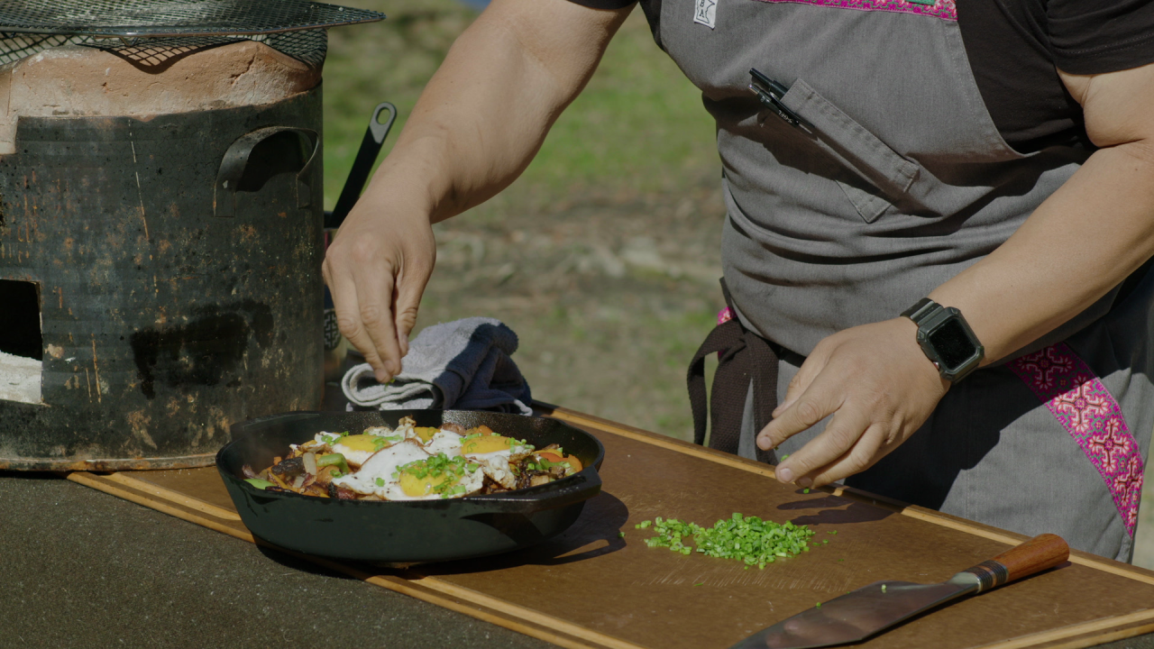 Yia Vang adding fresh scallions on top of the duck eggs