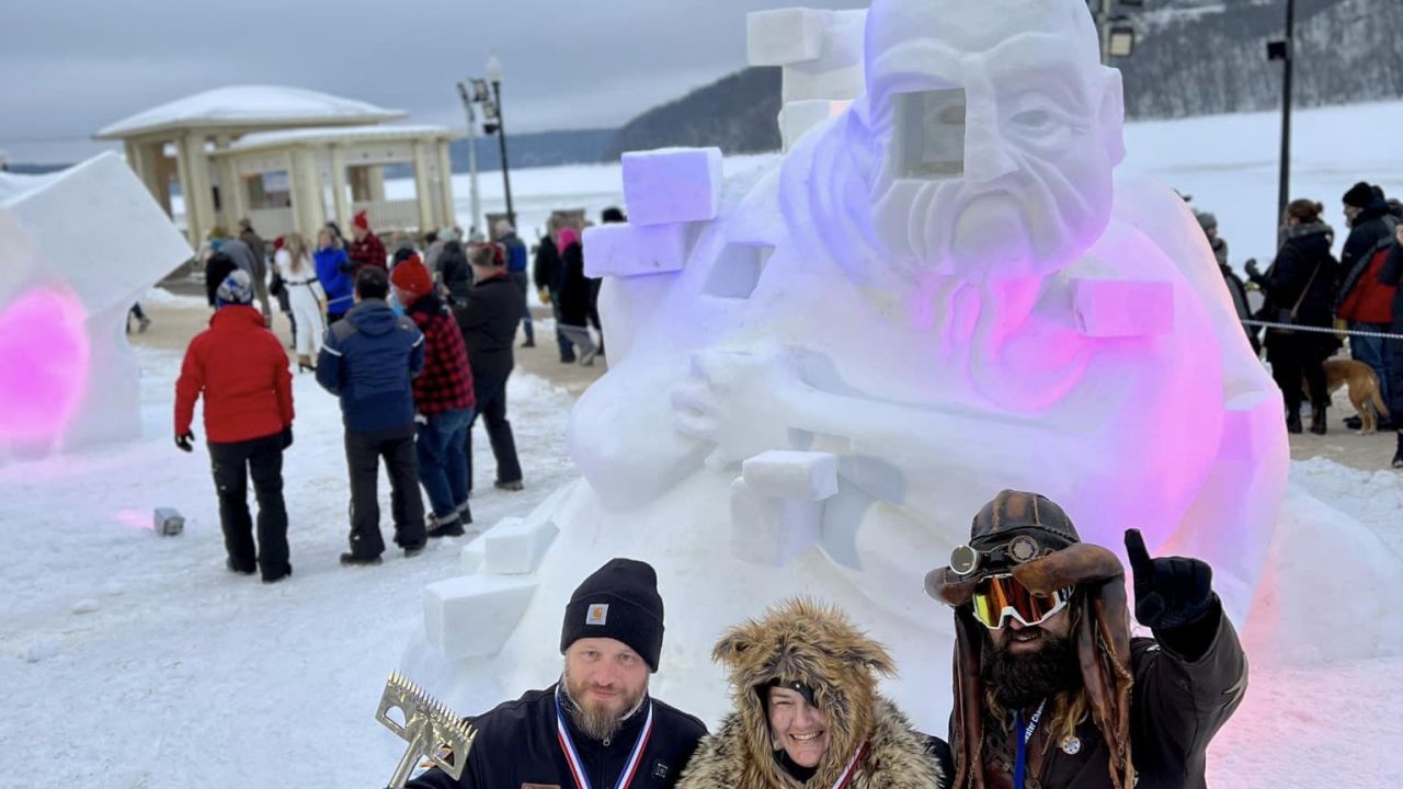 The winners of 2023's World Snow Sculpting Championship pose with their piece