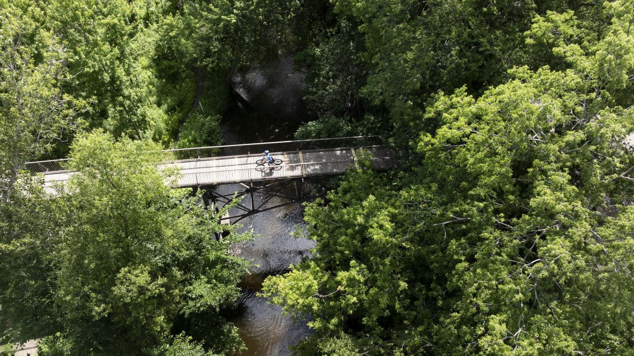 A biker crosses a bridge in Lynnhurst Park