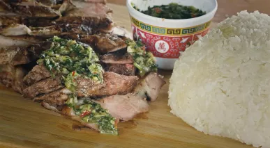 Sliced pork coppa dressed with a finely chopped sauce, accompanied by a mound of sticky rice